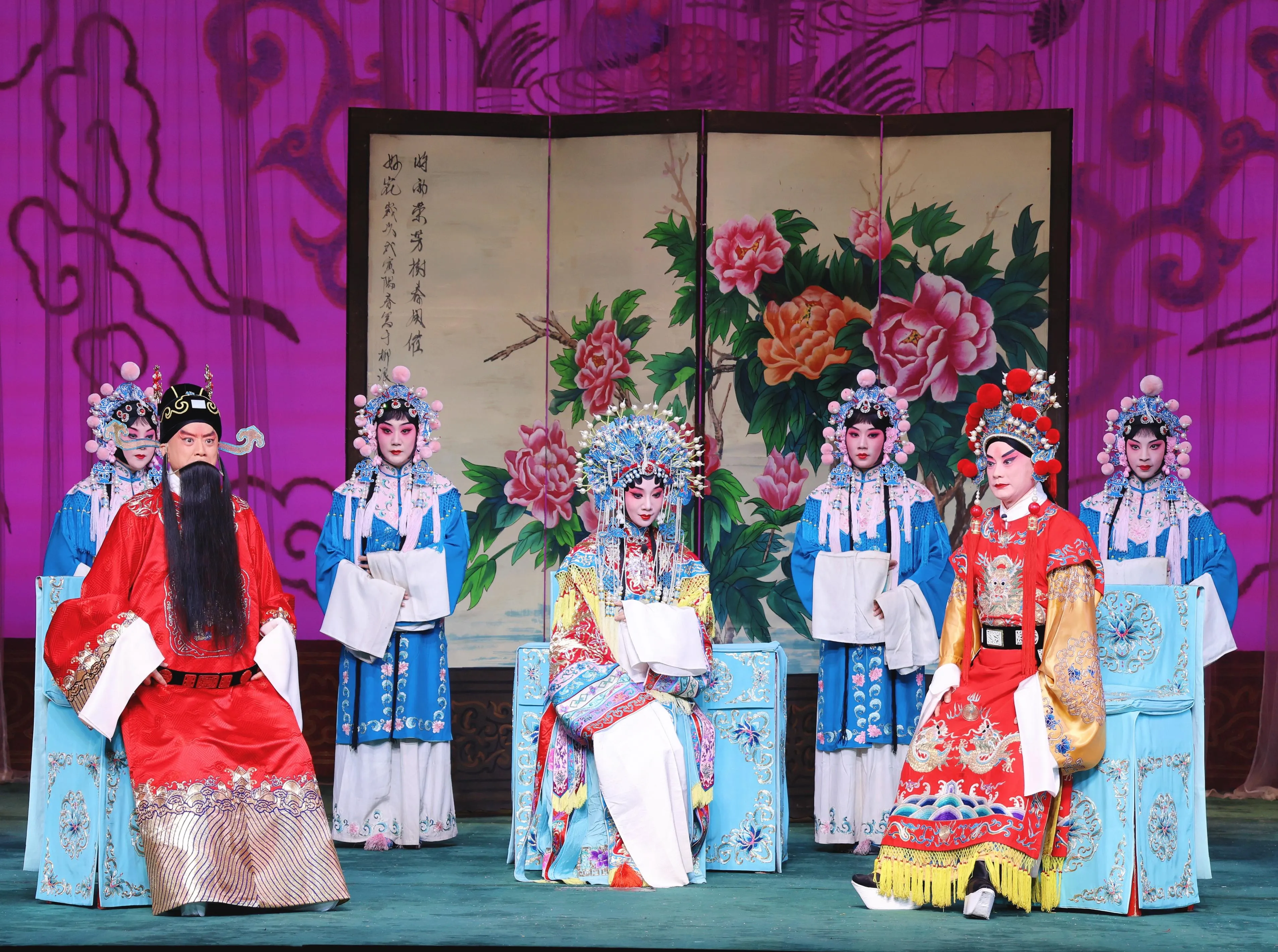 A Peking Opera performer in elaborate gold robes and painted face performing on a traditional wooden stage.