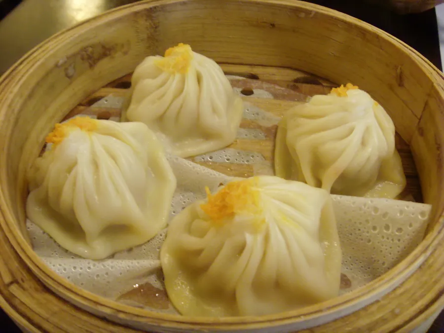 Steamed soup dumplings served in a bamboo basket.