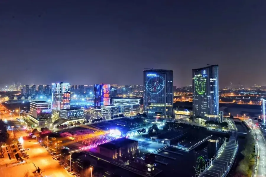 Sleek glass-and-steel offices and modern green landscaping in Wuxi New District under a clear sky.