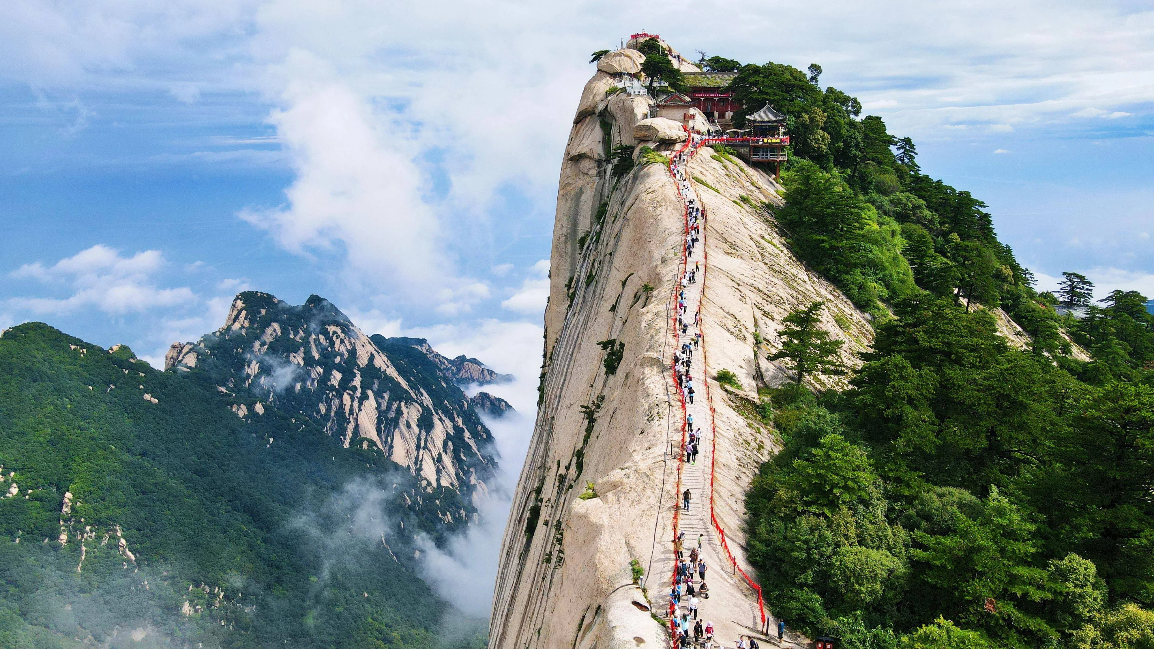 Sheer vertical granite peaks of Mount Hua shrouded in morning mist.